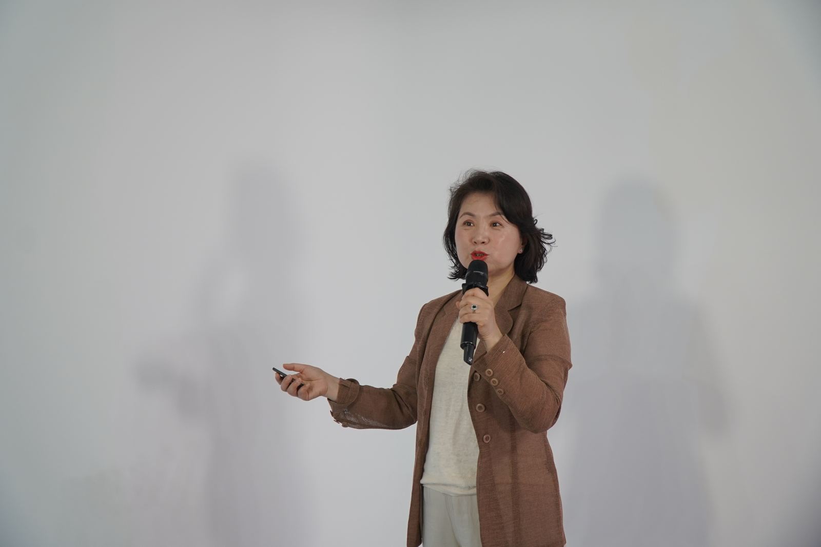 마이크와 리모컨을 들고 설명하는 가인지의 교육 장면